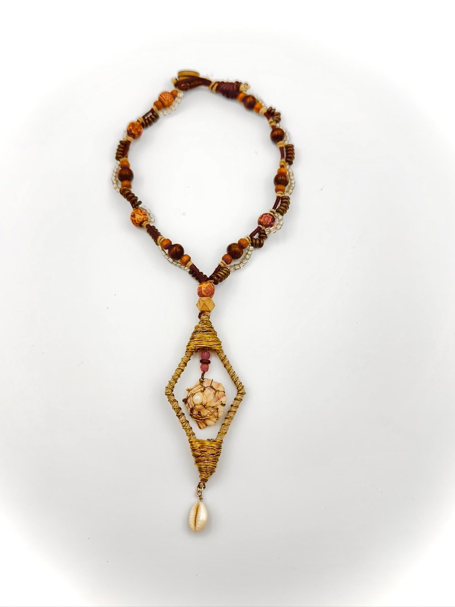 Necklace with beads and a decorative pendant on a white background