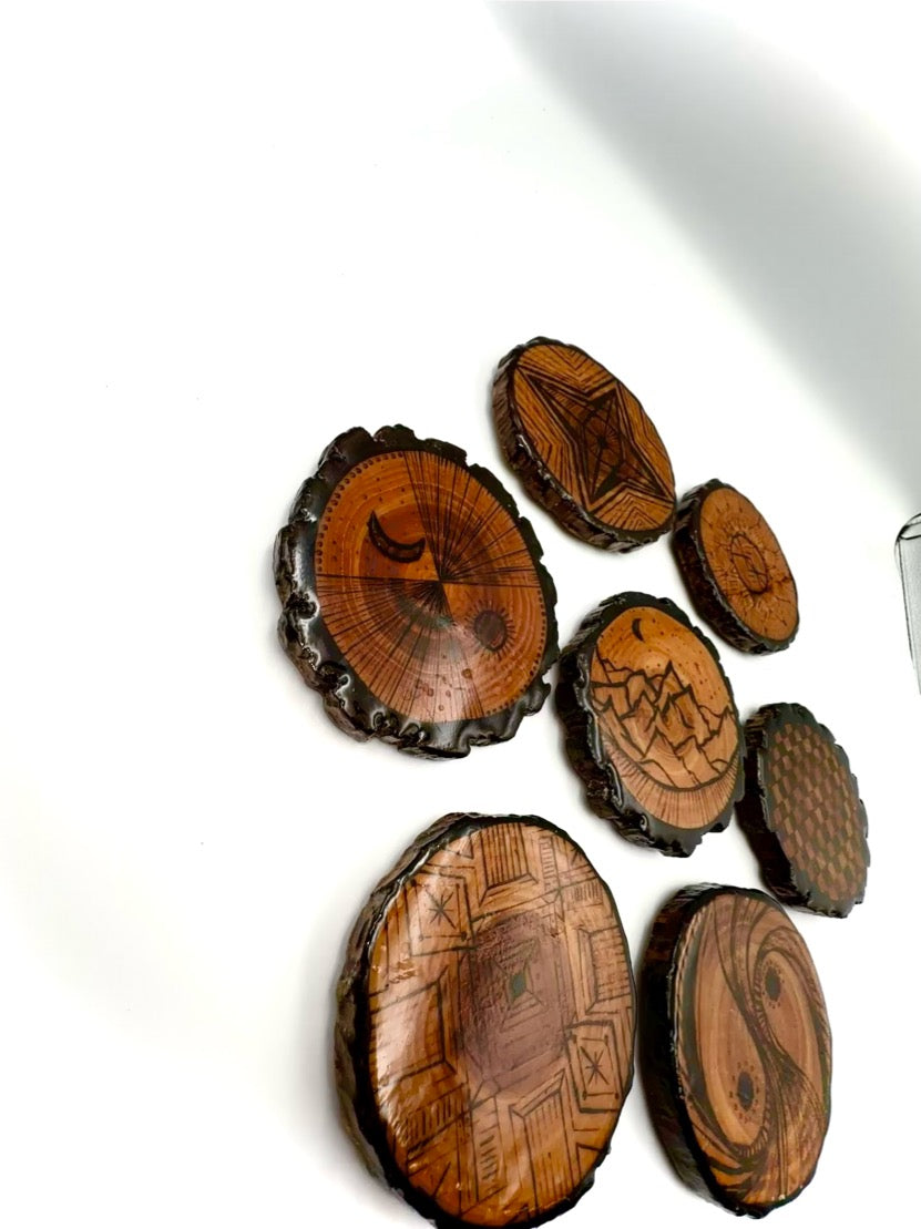 Wooden coasters with engraved designs on a white background
