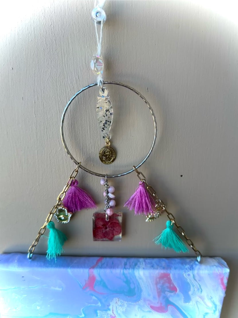 Decorative hanging ornament with tassels and beads on a plain background