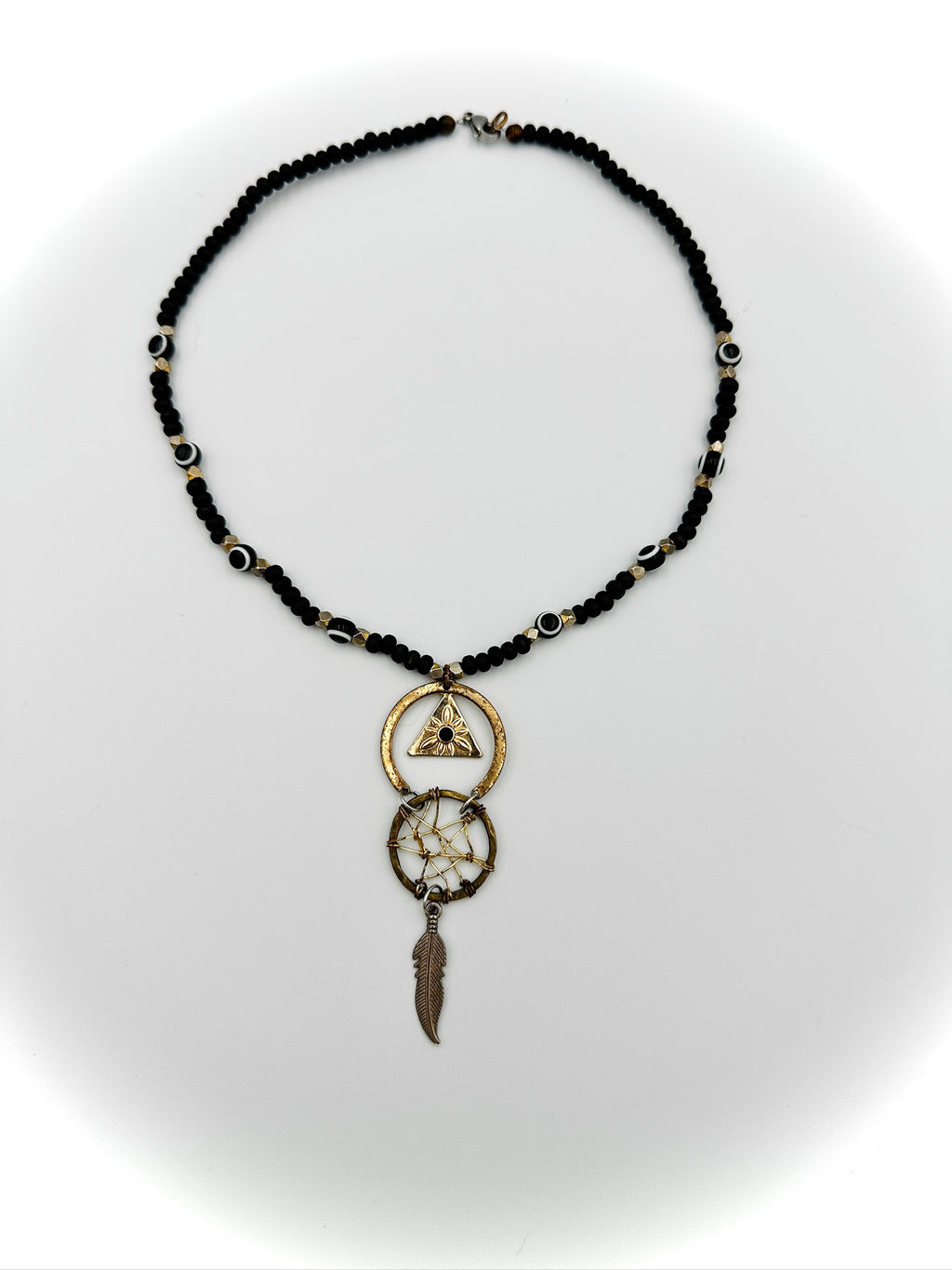 Necklace with black beads and gold accents on a white background