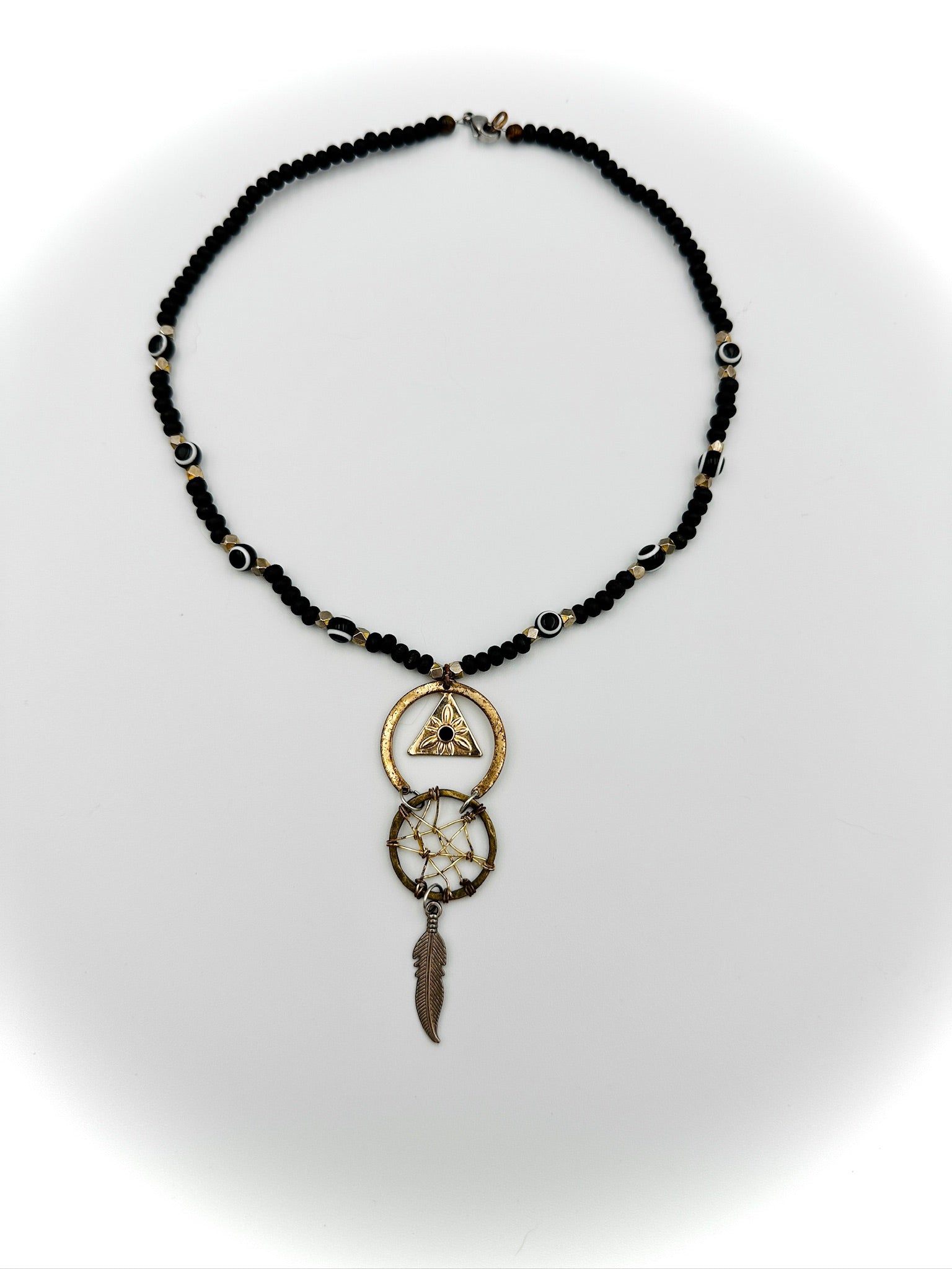 Necklace with black beads and gold accents on a white background