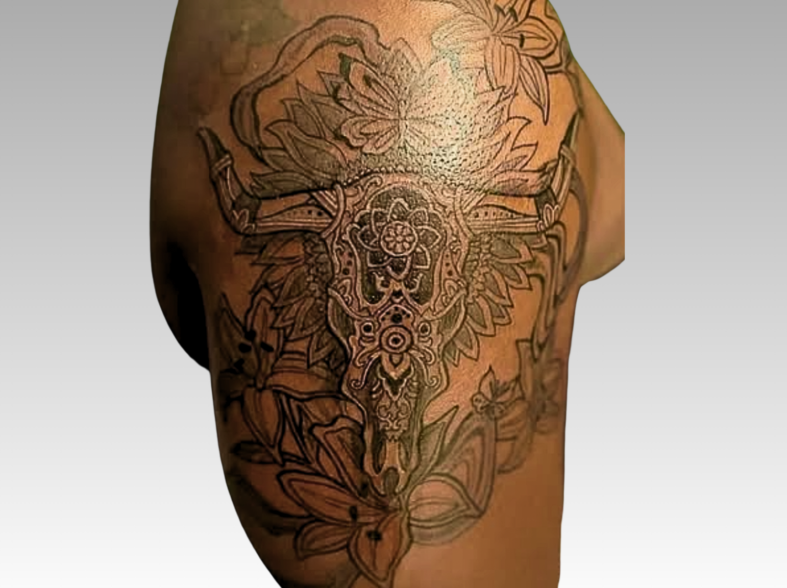 Detailed tattoo design on a person's arm with flowers and geometric patterns.