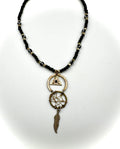 Necklace with black beaded chain and dreamcatcher pendant on a white background