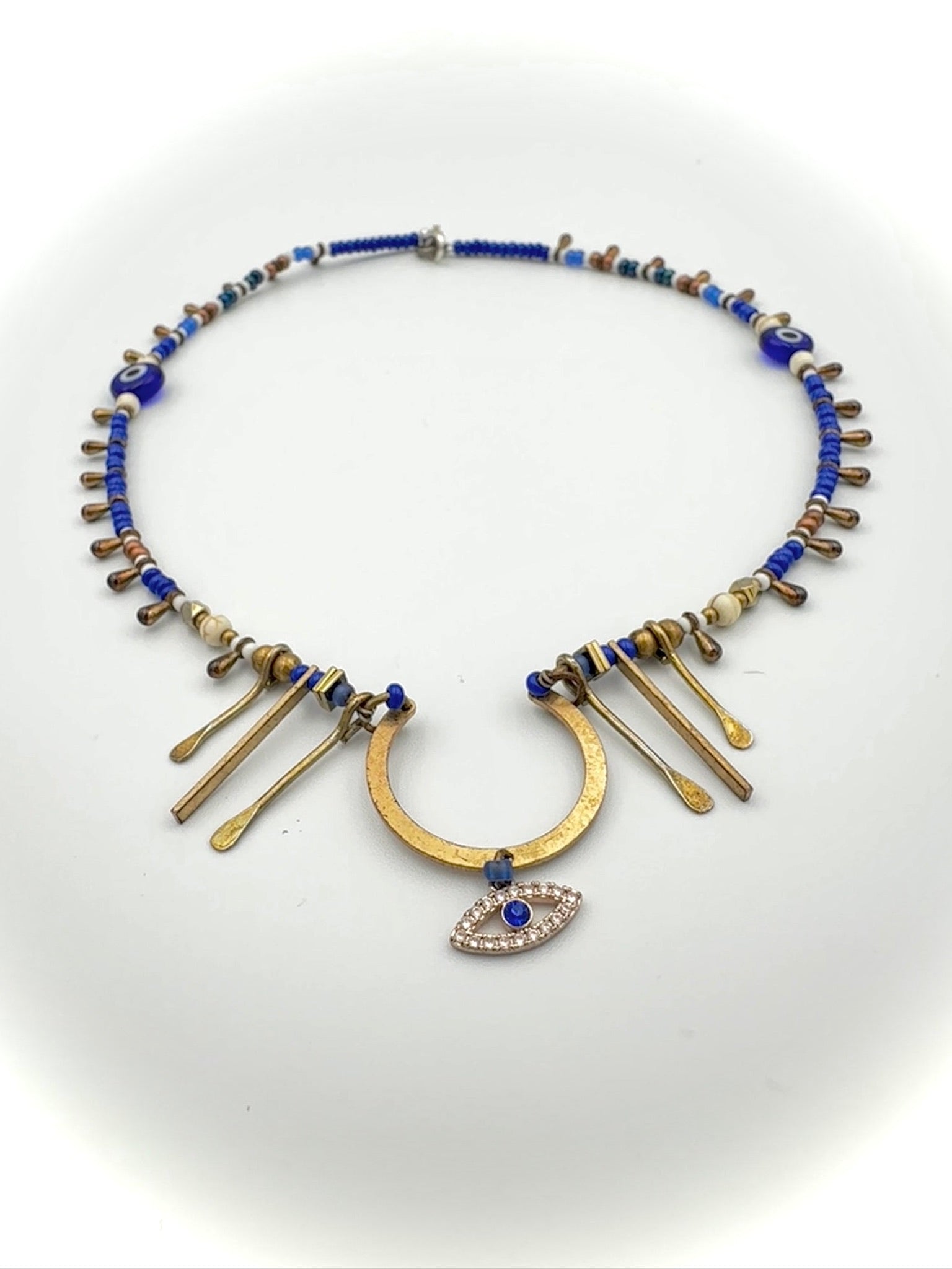 Necklace with blue beads and gold accents on a white background