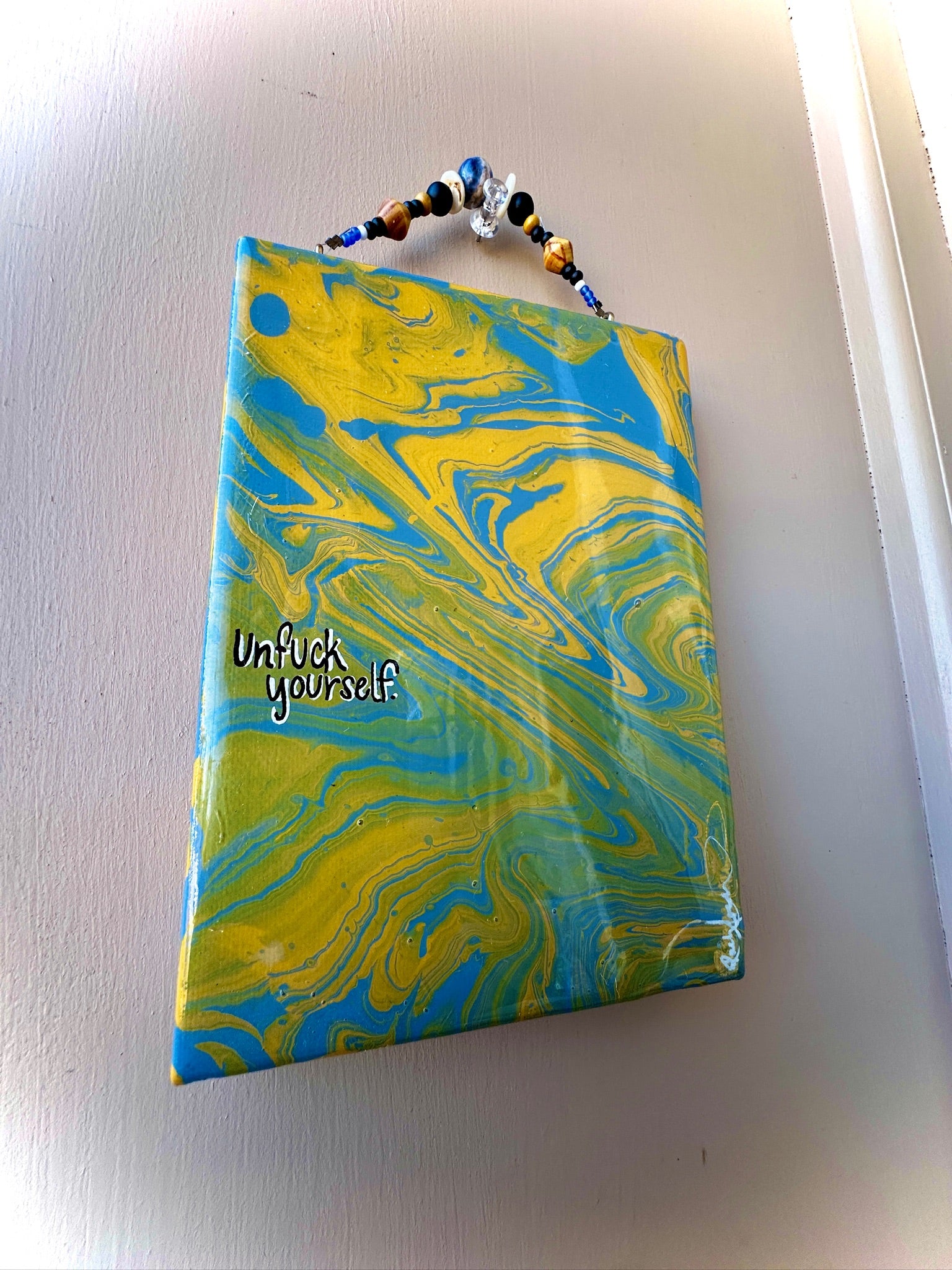 Marbled notebook with 'Unfuck yourself' text on a plain background