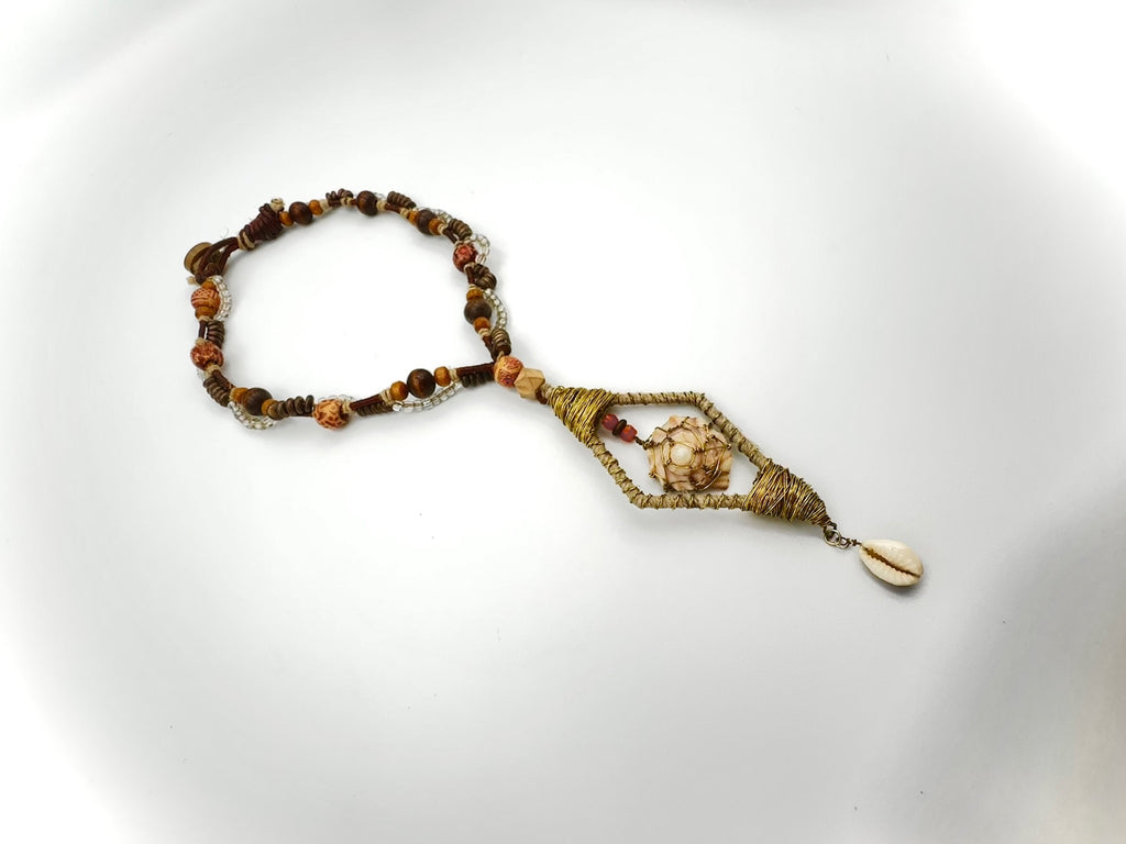 Beaded bracelet with shell charm on a white background