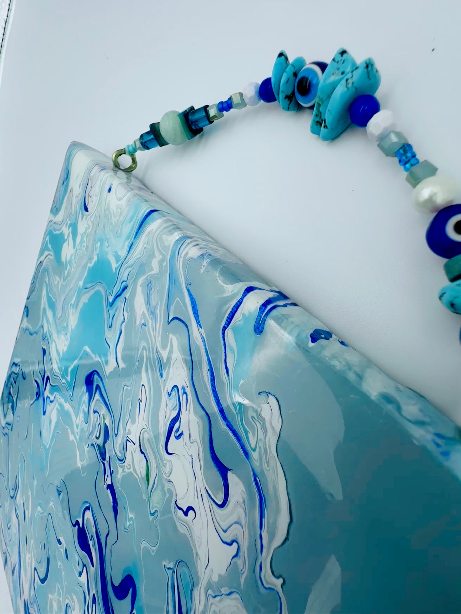 Necklace with blue and green beads on a white surface