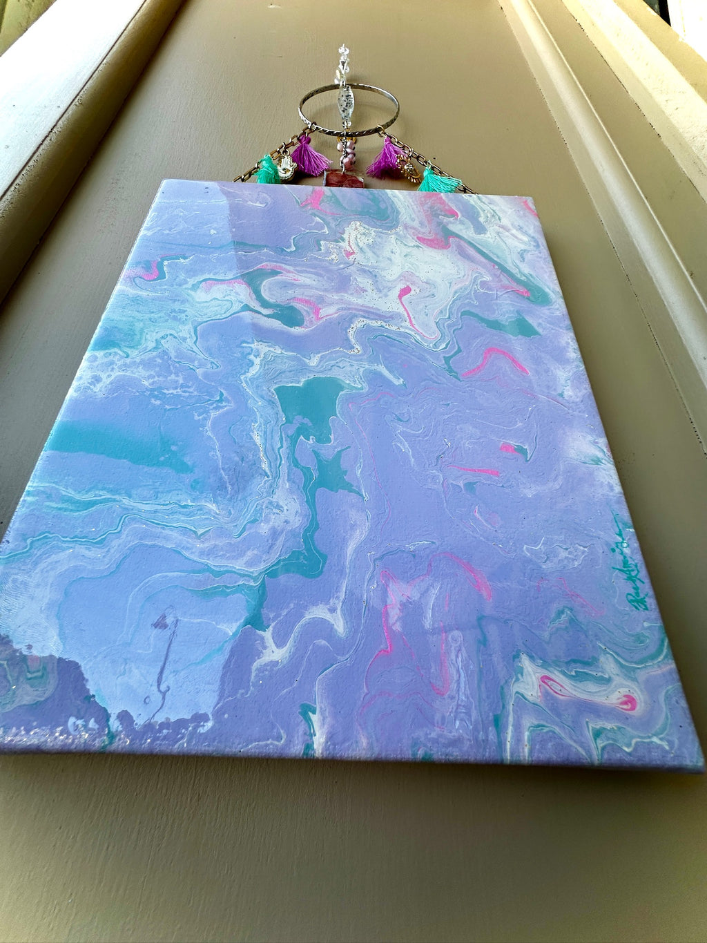 Marbled painting with blue and pink hues on a beige surface