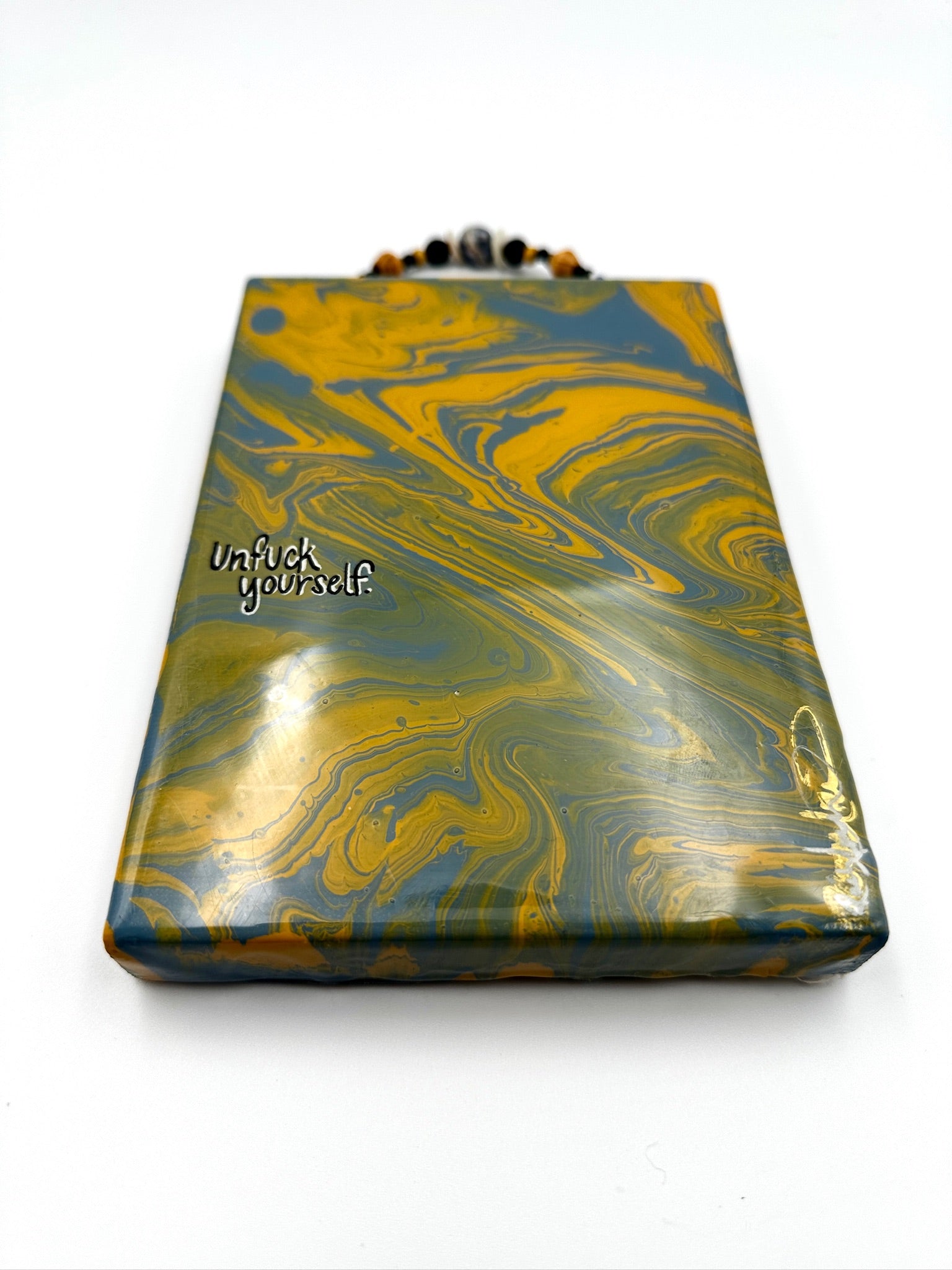 Marbled patterned pouch with 'Unflick yourself' text on a white background