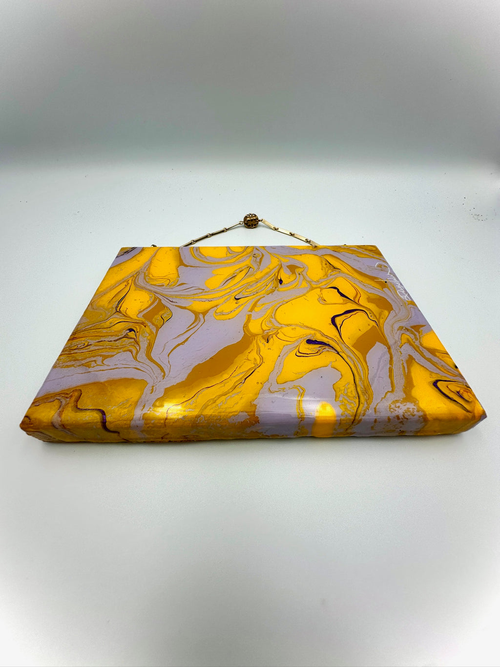 Marbled yellow and gray clutch bag on a white background