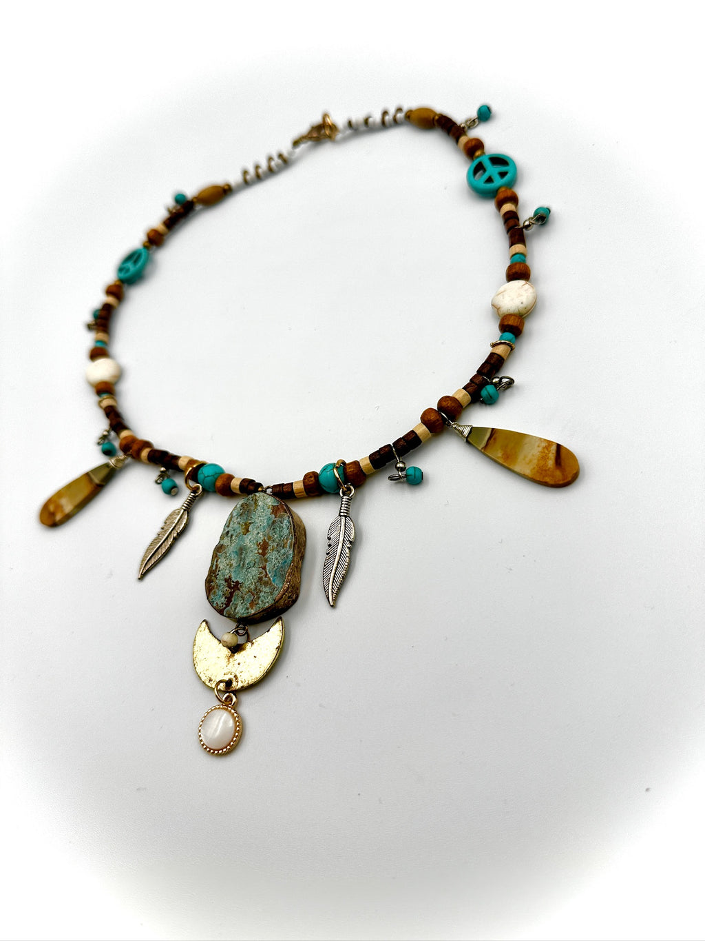 Necklace with various beads and pendants on a white background