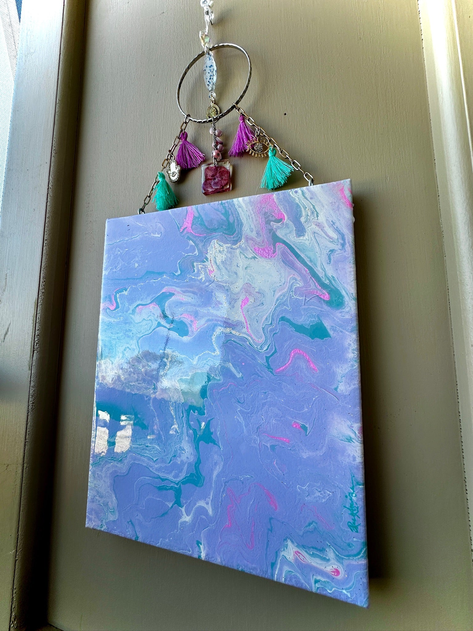 Decorative keychain with colorful beads on a marbled purple and blue background