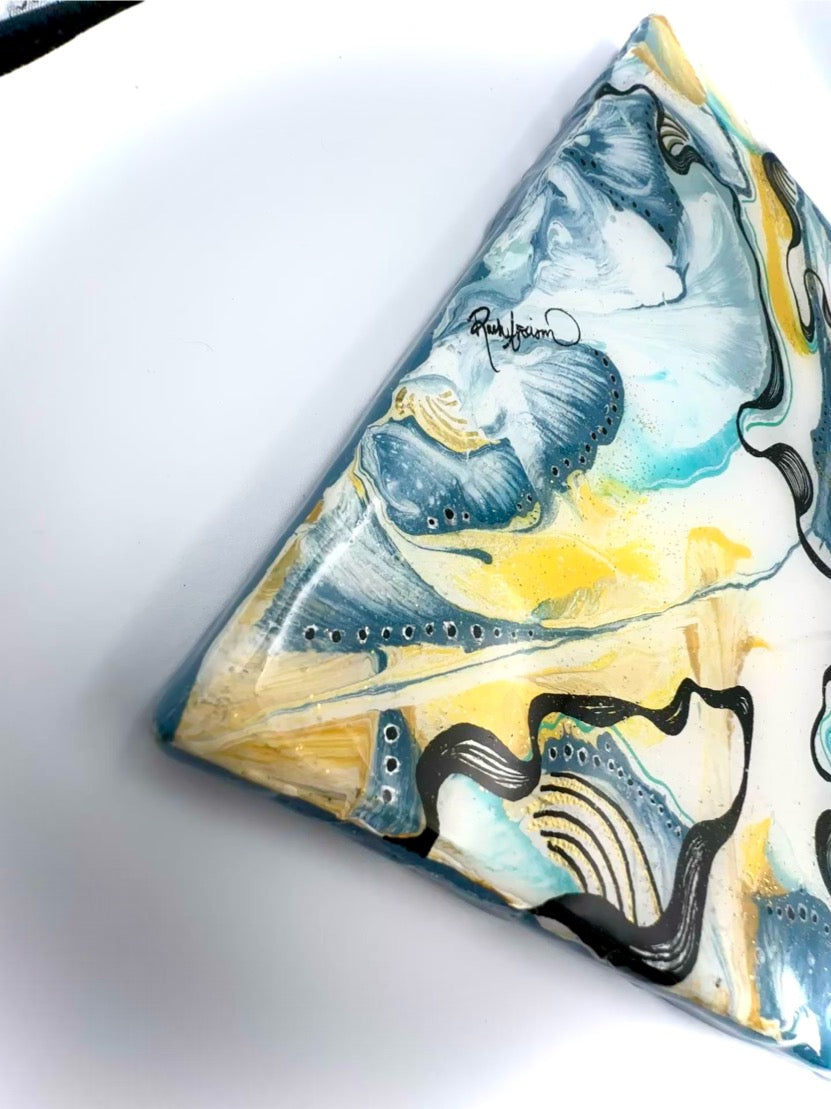 Triangular pillow with whale design on a white background