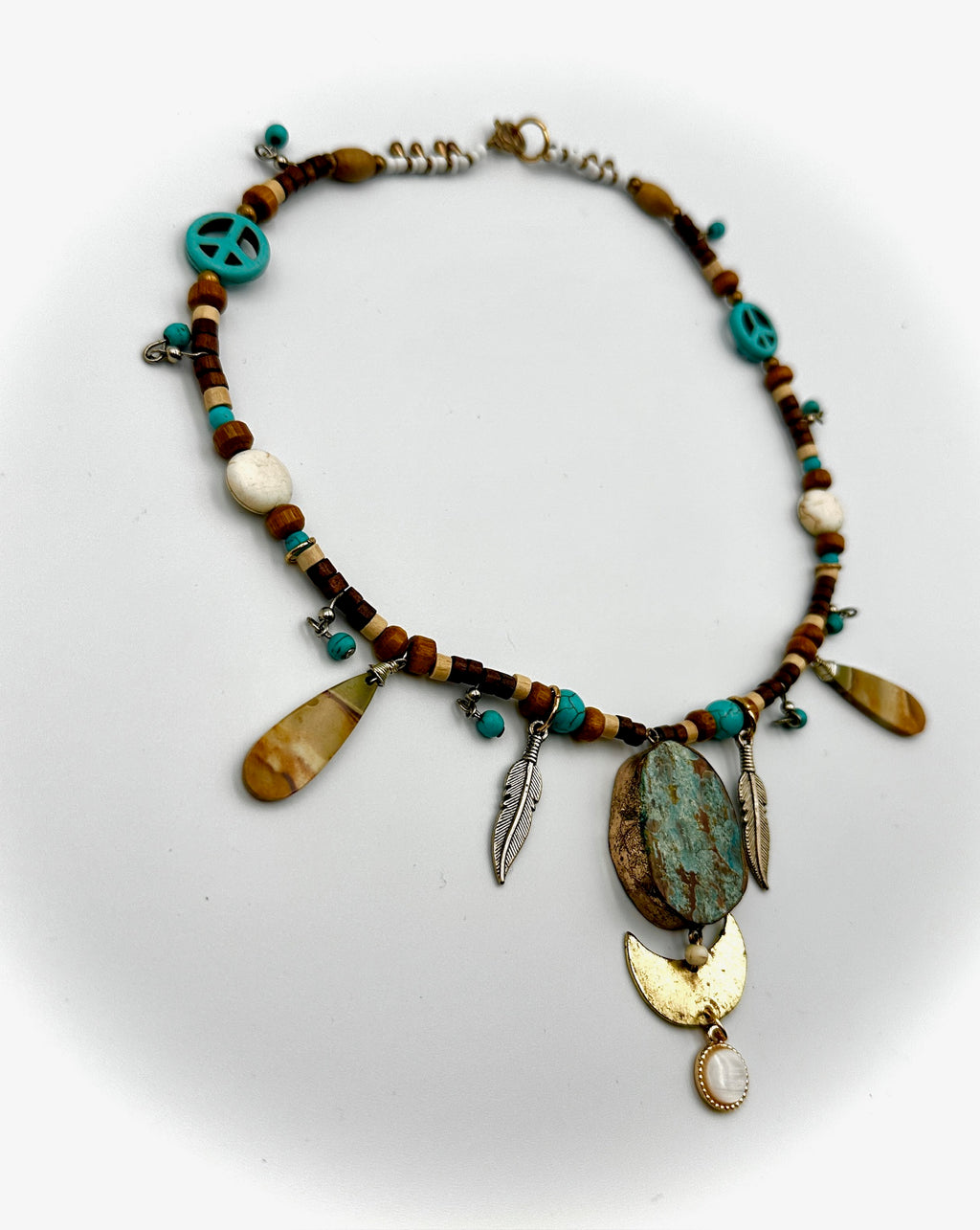 Necklace with various beads and charms on a white background