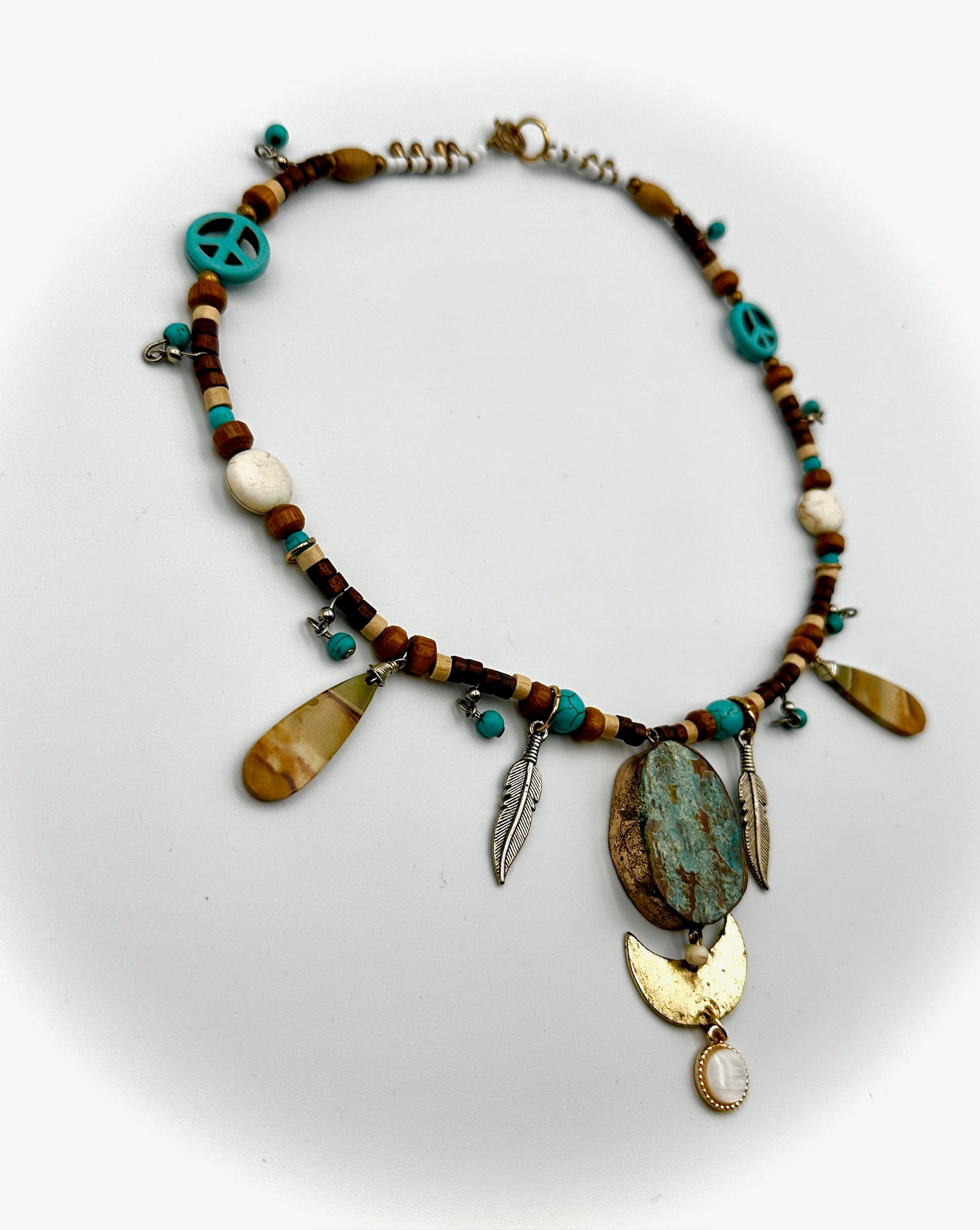 Necklace with various beads and charms on a white background