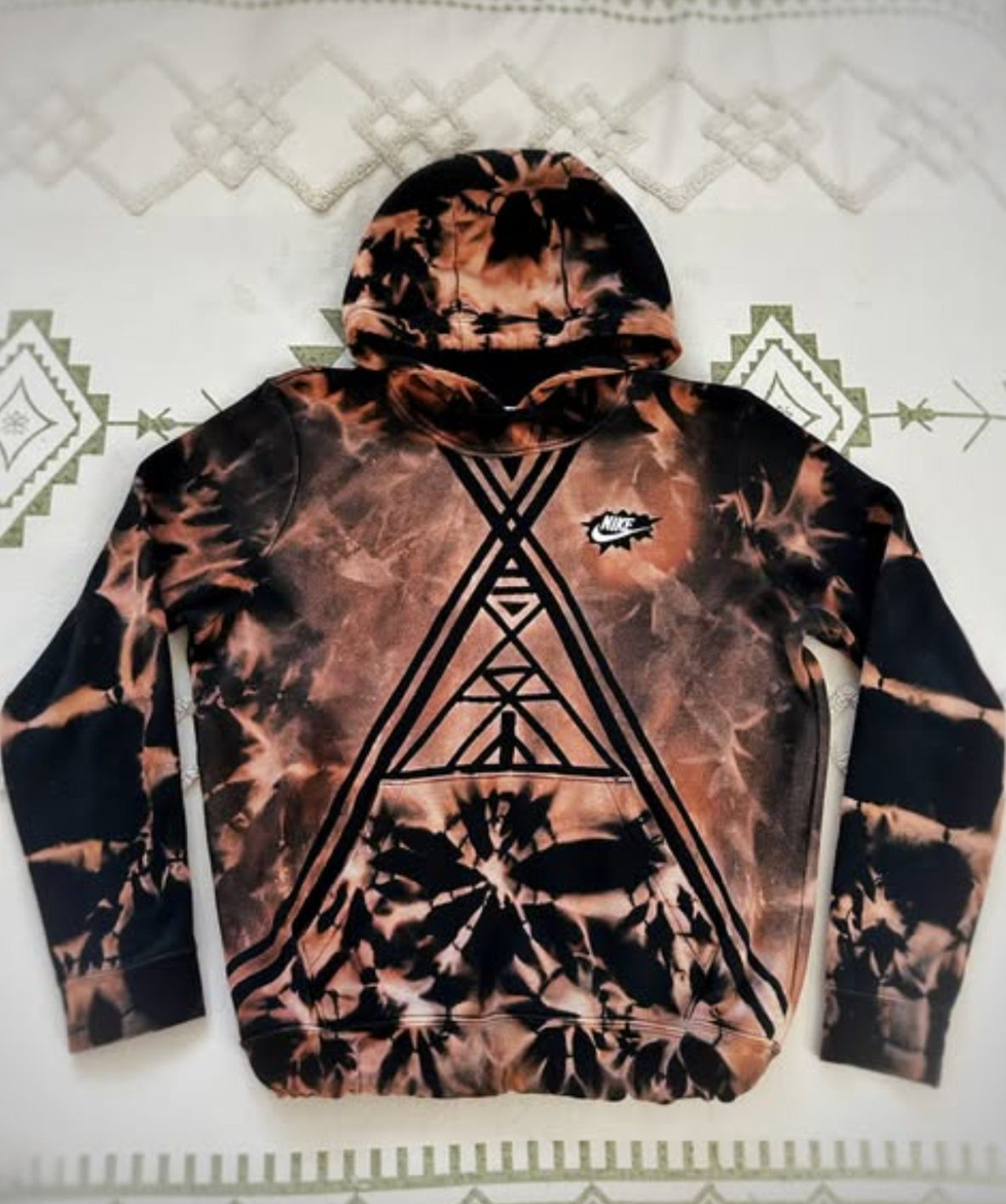 Tie-dye hoodie with geometric design on a white background